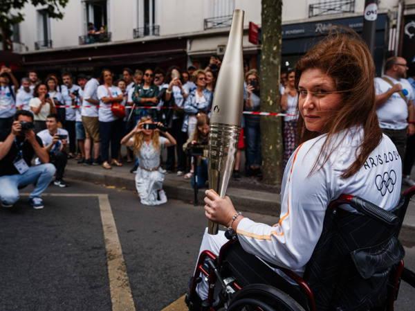 A Lebanese photojournalist, wounded in Israeli strike, carries Olympic torch to honor journalists